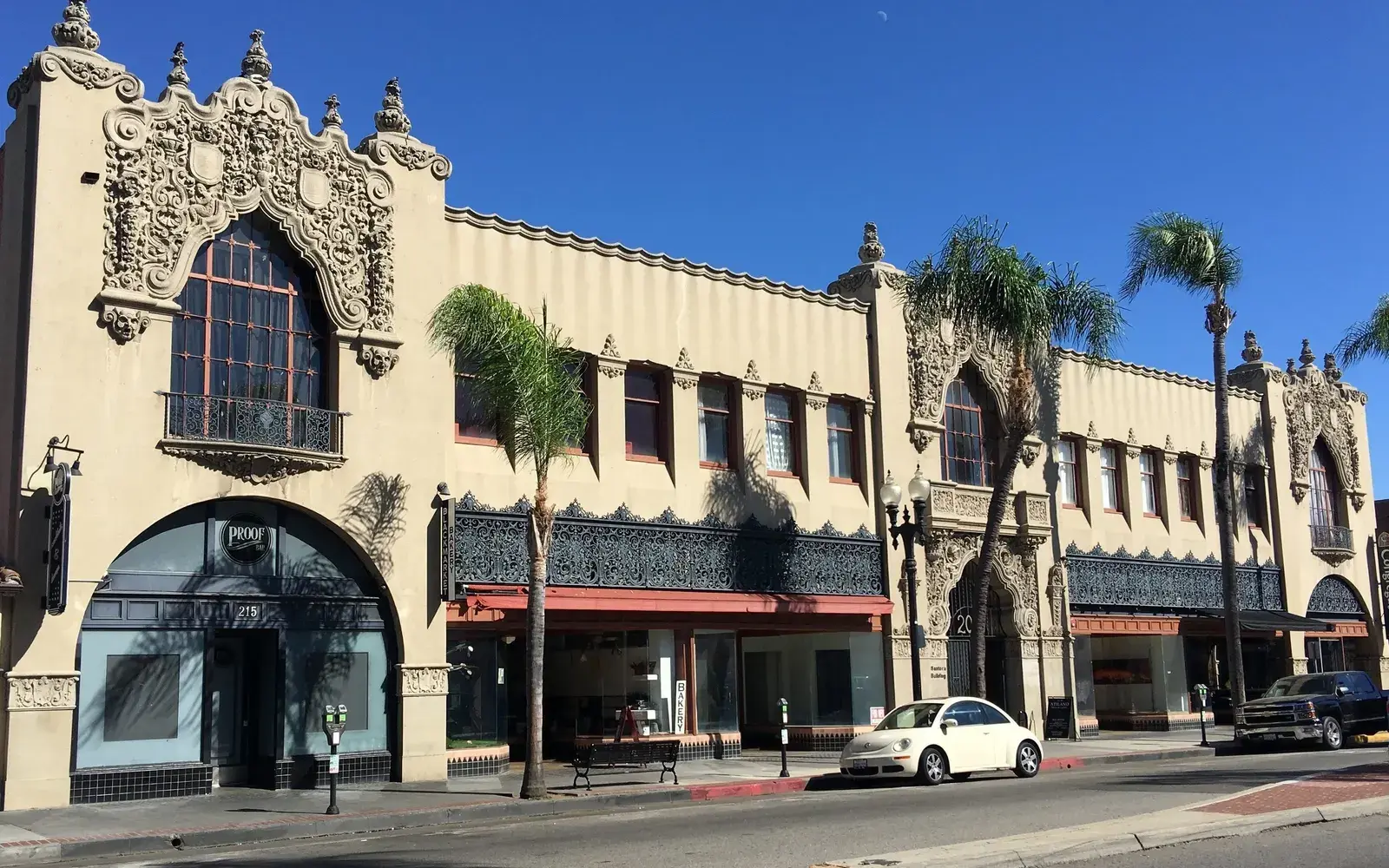 Historic Spanish Colonial Revival storefront building with palm trees in downtown Santa Ana, CA