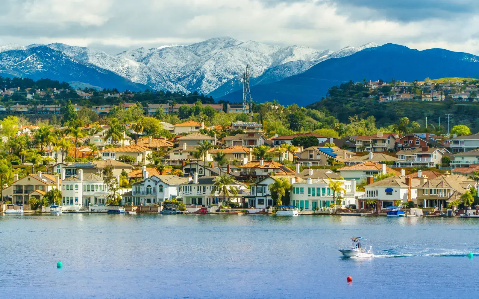 Waterfront buildings along Lake Mission Viejo with snow-capped mountains behind, Mission Viejo, CA Waterfront buildings along Lake Mission Viejo with snow-capped mountains behind, Mission Viejo, CA